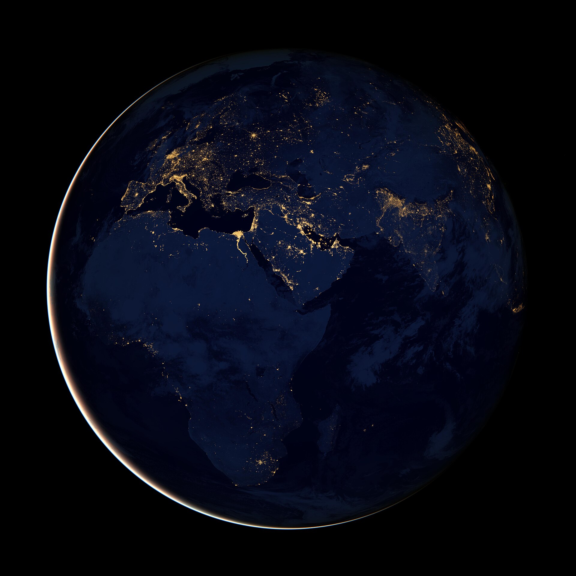 NASA Black Marble satellite view of Earth at night — city lights glowing across Africa, Europe, and the Middle East.